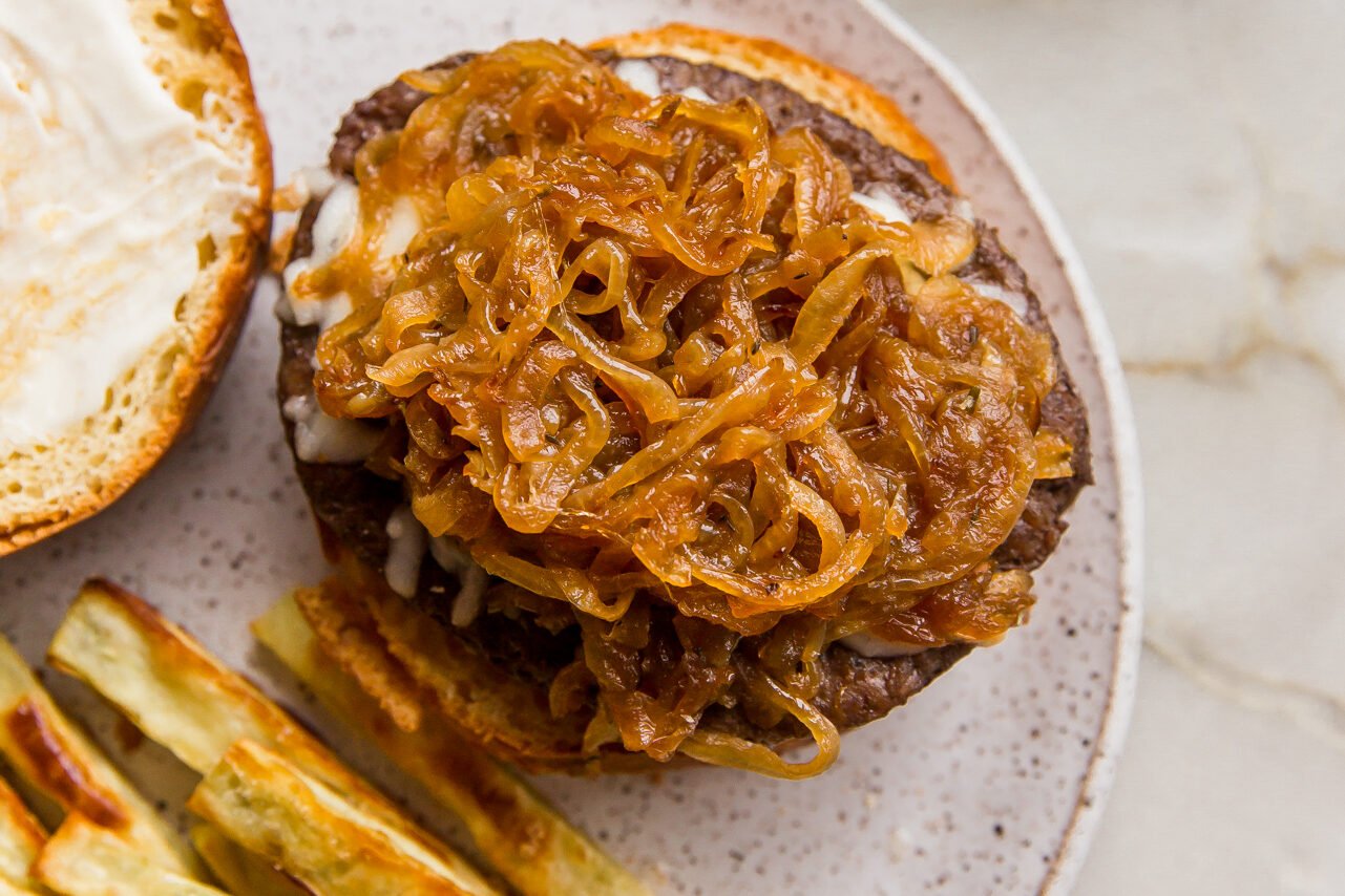 French onion burger on a bun, served open face. 