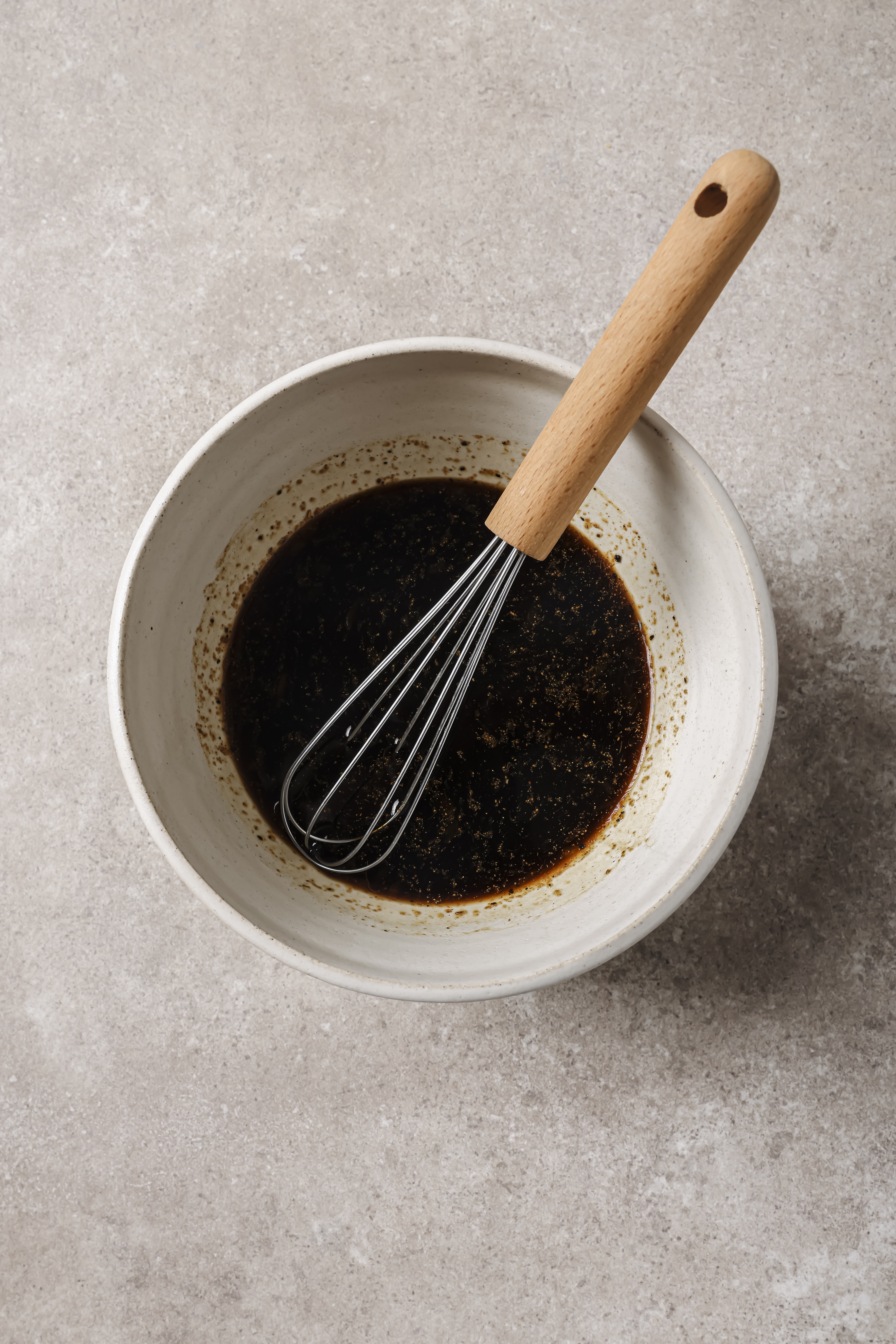 all ingredients for sauce mixed together in a bowl with a whisk