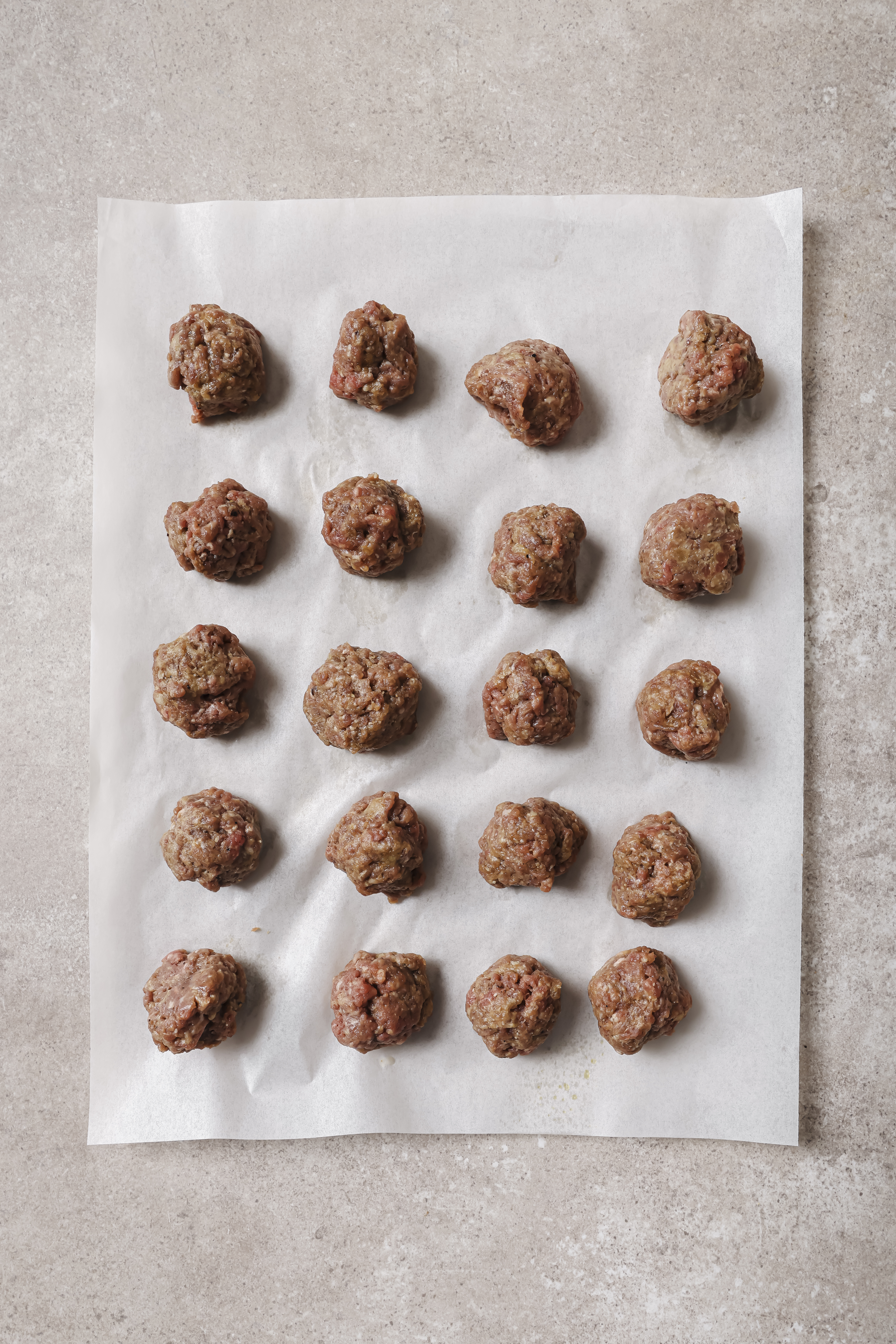 uncooked meatballs on parchment paper