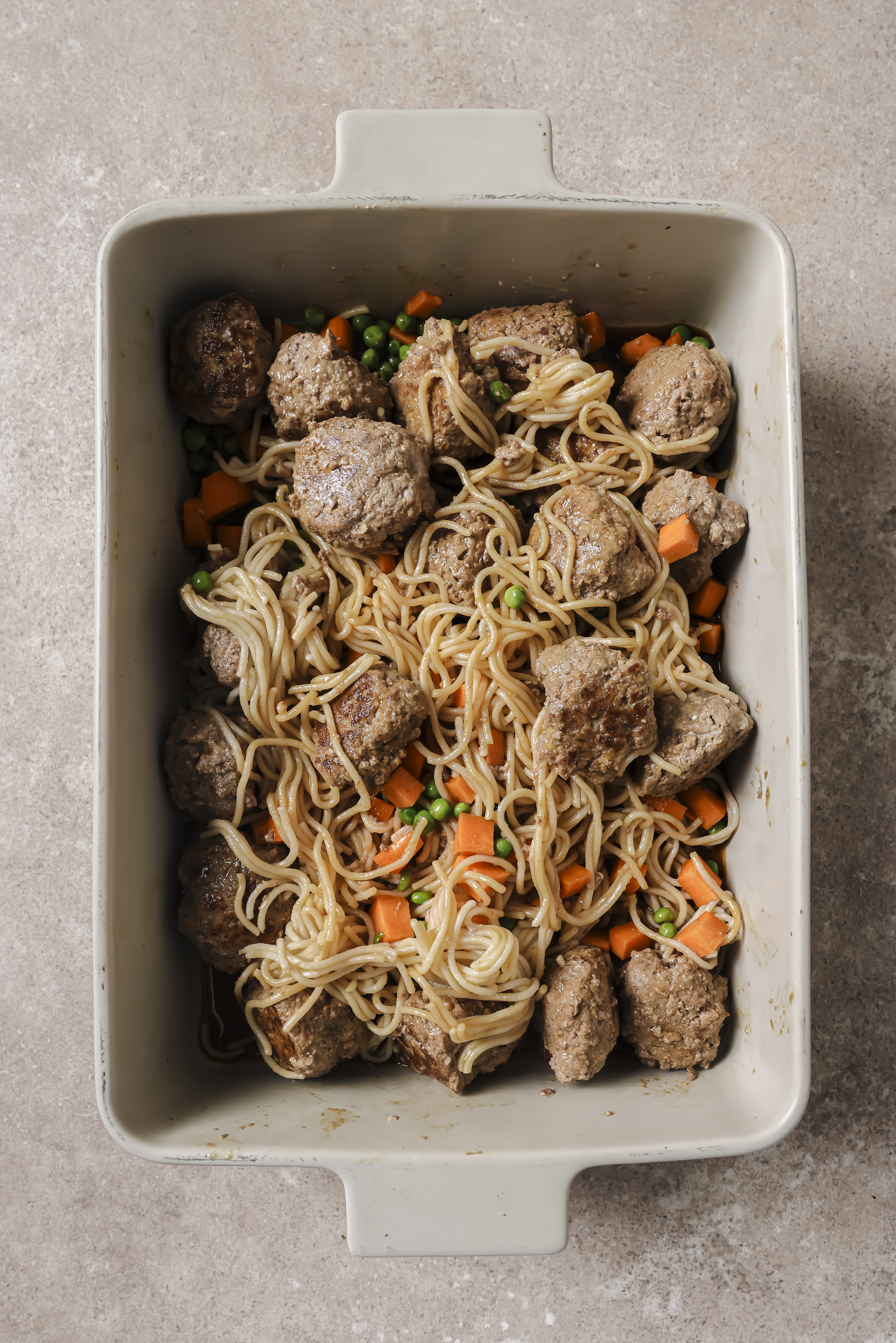 ramen, meatballs, and veggies combined in a. casserole dish