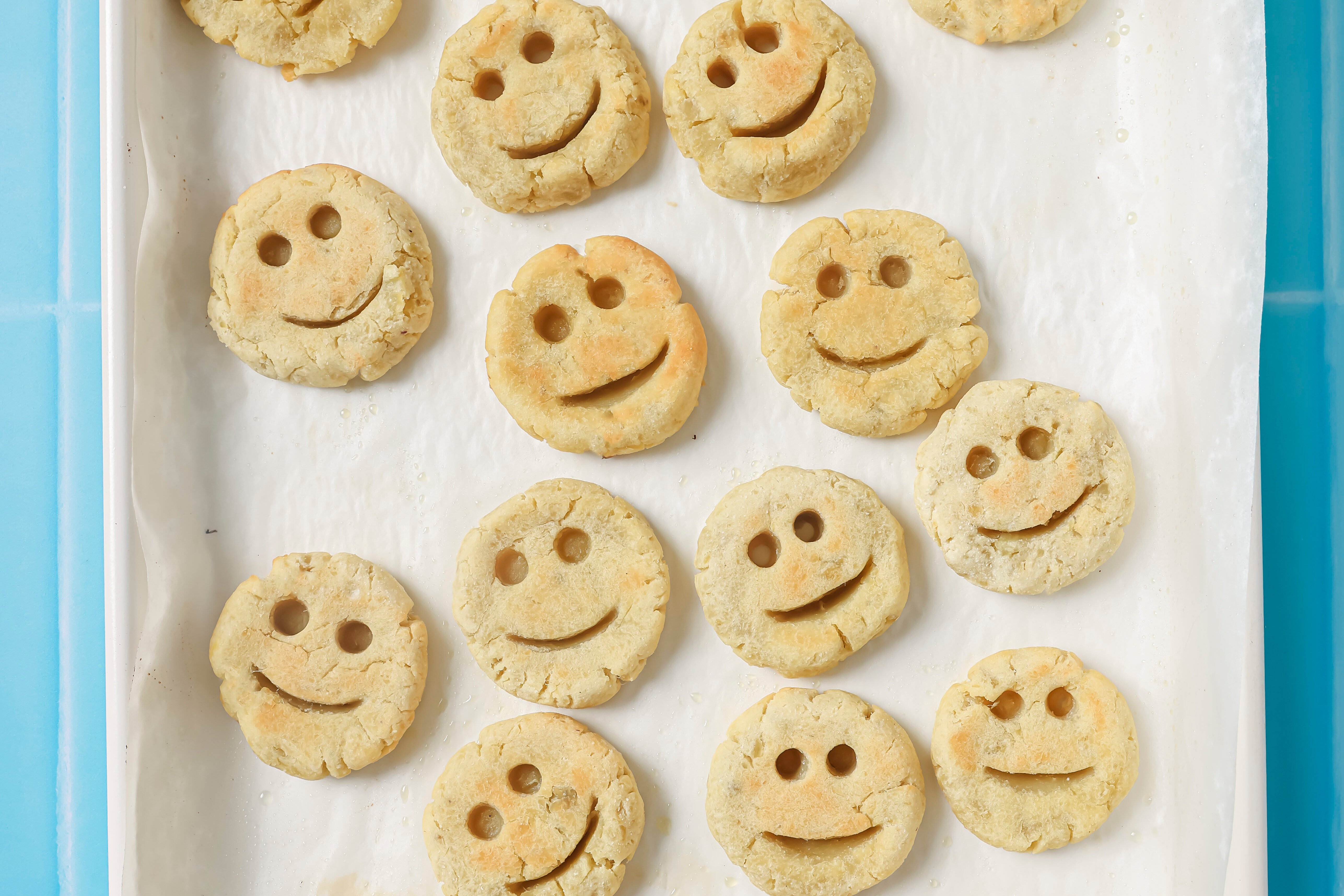 Smiley fries baked on a baking sheet.