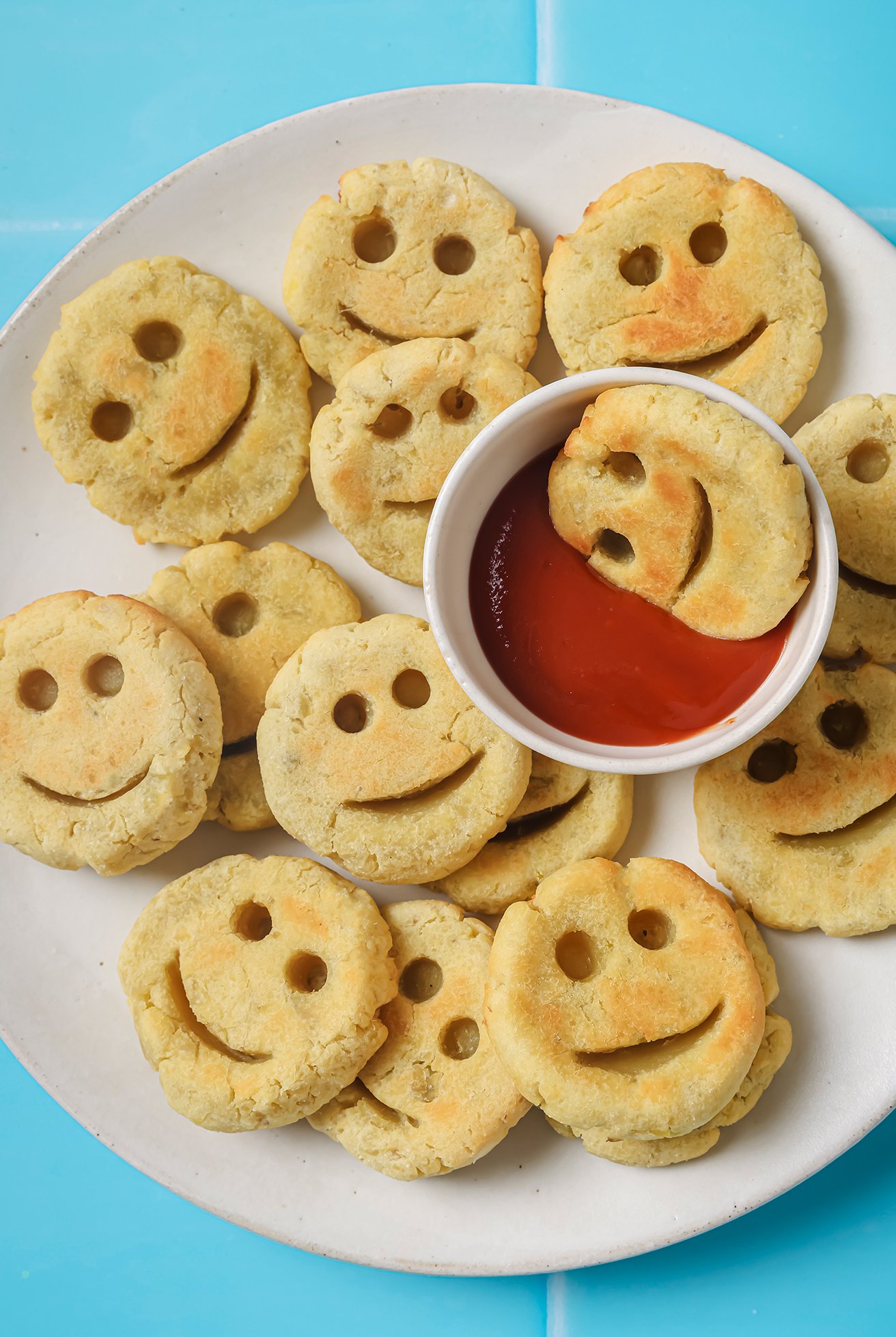 Sweet potato smiley fries on a plate with ketchup.