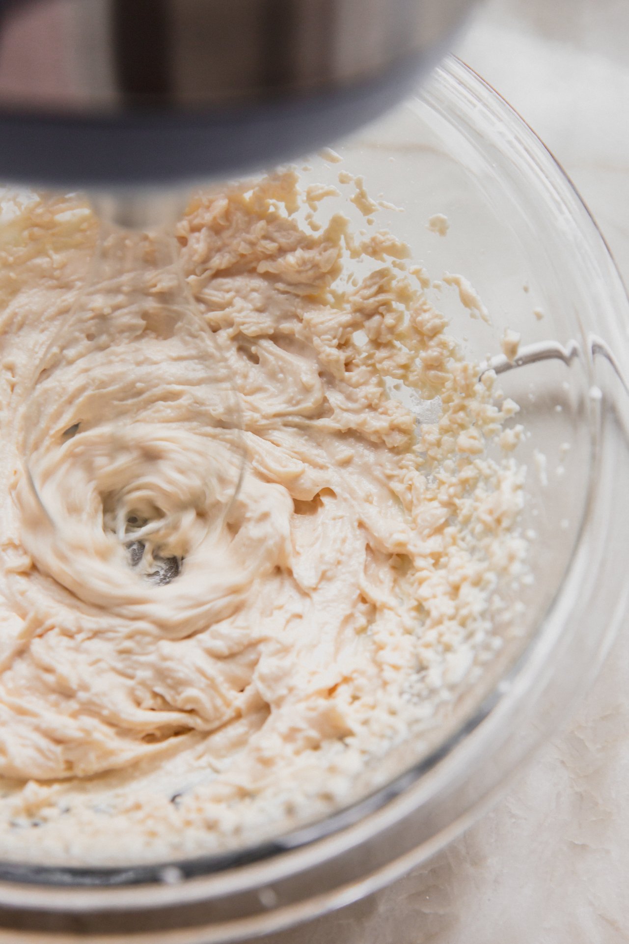 The cannoli cream being mixed by a mixer.