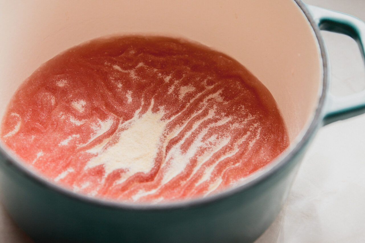 The fruit juice and gelatin before mixing in a pot.
