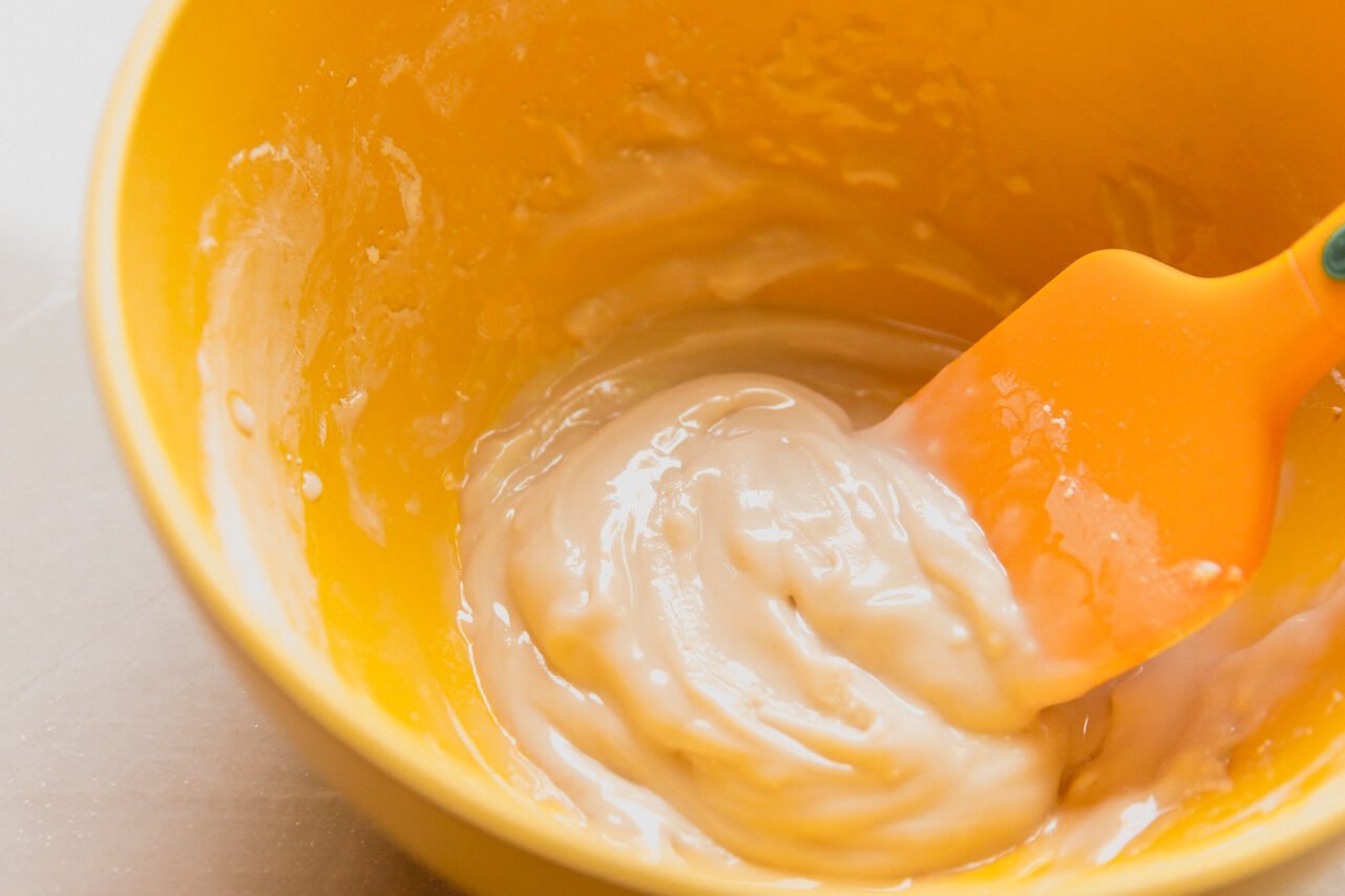 A bowl of powdered sugar, water, and vanilla extract mixed together to form a paste.