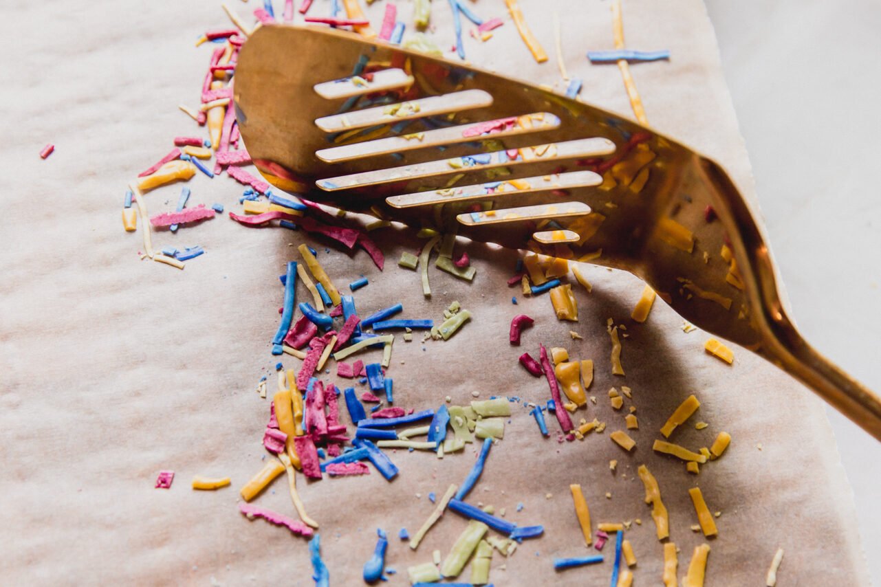 A spatula breaking up the dried paste to make homemade sprinkles.