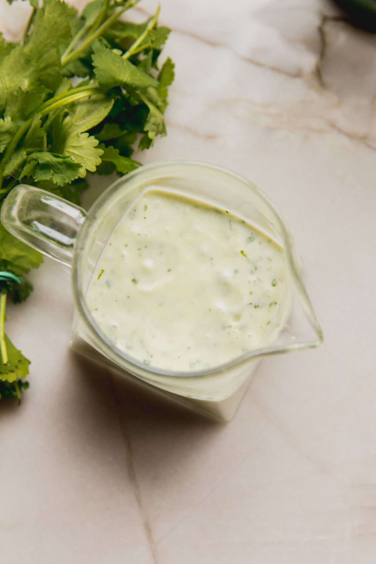 A glass jar of homemade taco salad dressing sitting on a counter.