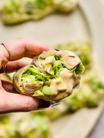Caesar rice paper roll cut in half with some dressing.