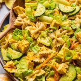 Ginger pasta salad in a bowl with a salad spoon.
