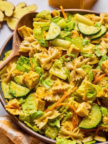 Ginger pasta salad in a bowl with a salad spoon.