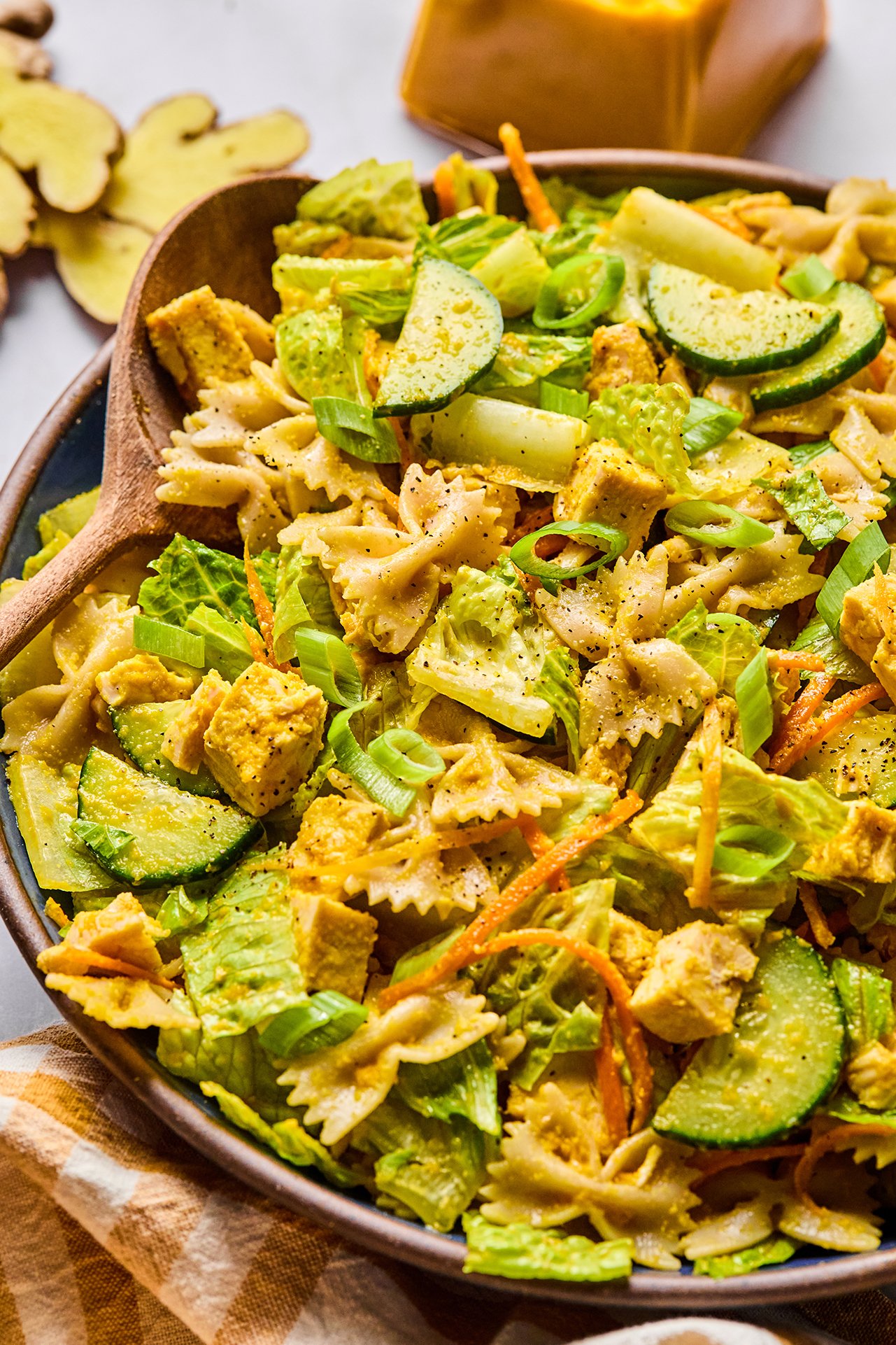 Ginger pasta salad in a bowl with a salad spoon.