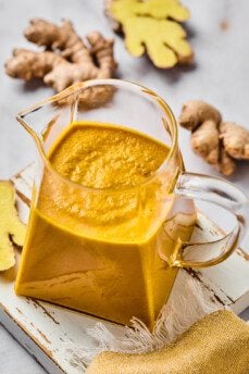 Japanese ginger dressing in a pitcher with fresh ginger on the side.