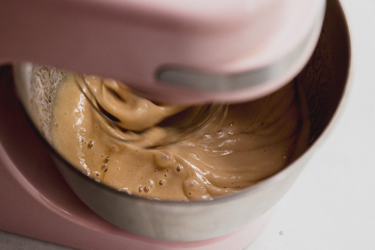 A stand mixer mixing the water and honey.