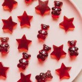 Tart cherry gummies on a pink plate.