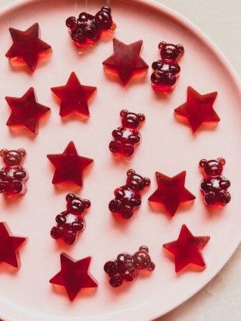 Tart cherry gummies on a pink plate.