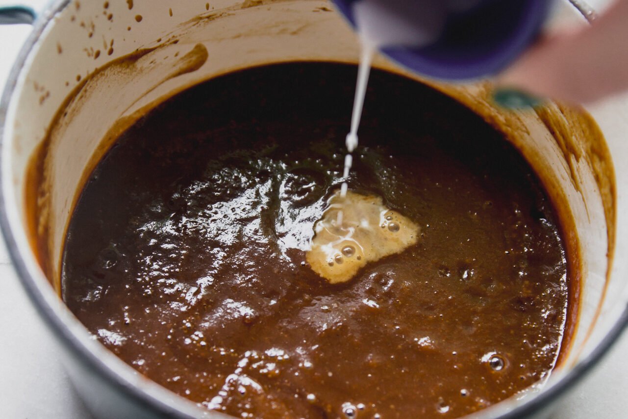 BBQ sauce with arrowroot slurry being poured in. 