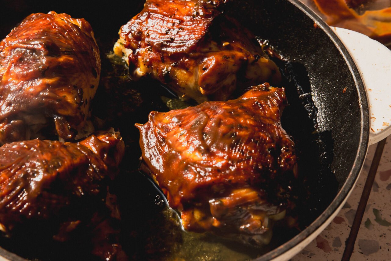 BBQ chicken thighs in a cast iron pan.