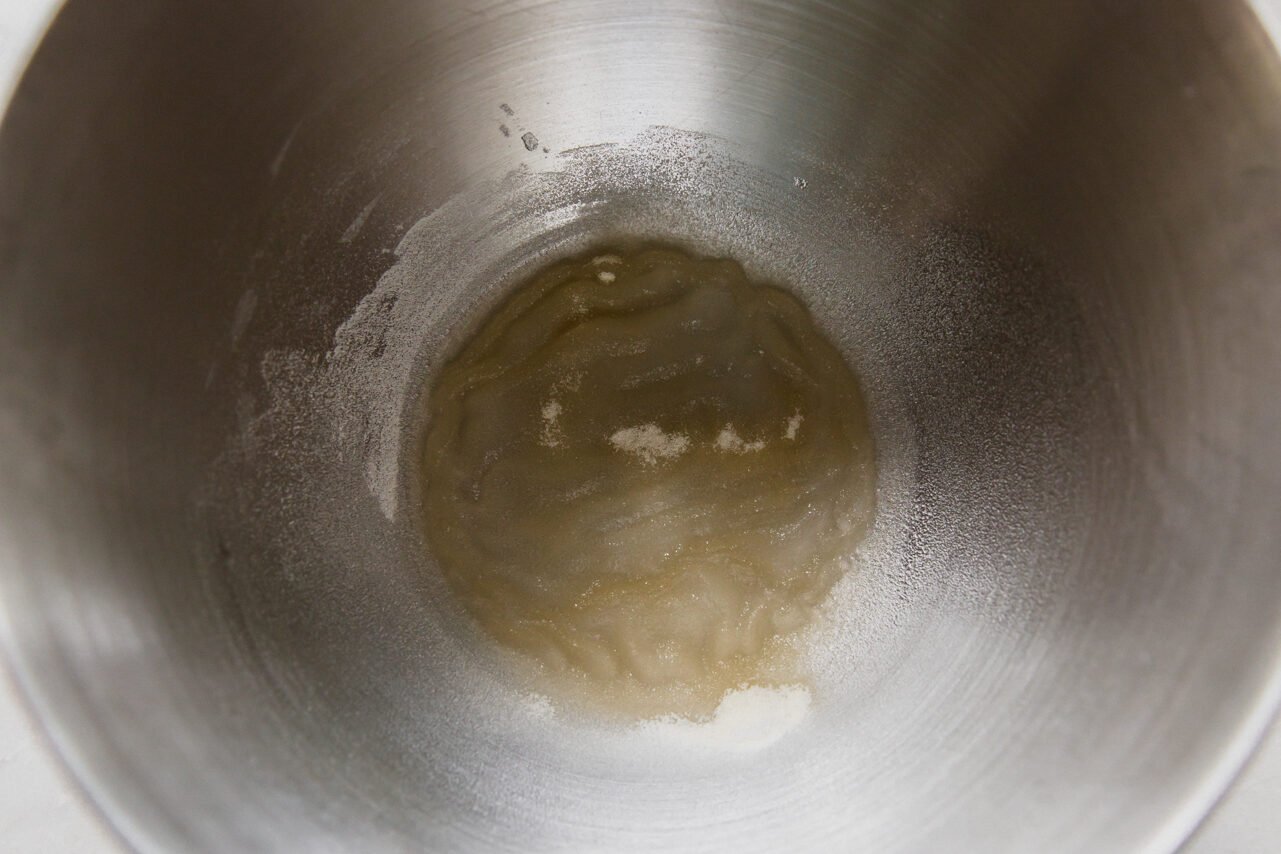 A stainless steel mixing bowl with gelatin and water setting. 