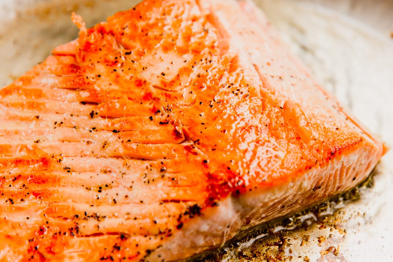 Salmon cooked in a stainless steel pan.