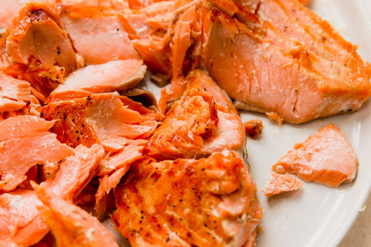 Salmon flaked on a plate.