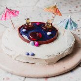Swimming pool cake topped with paper umbrellas.
