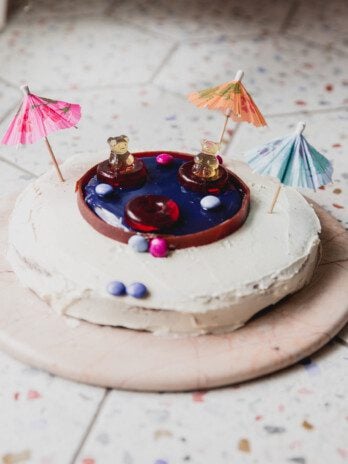 Swimming pool cake topped with paper umbrellas.