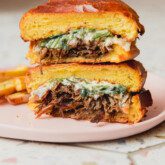 Pot roast sandwich sliced in half and stacked.