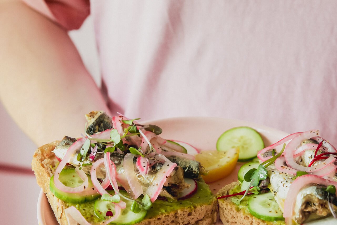 A plate with two pieces of sardine toast on it.
