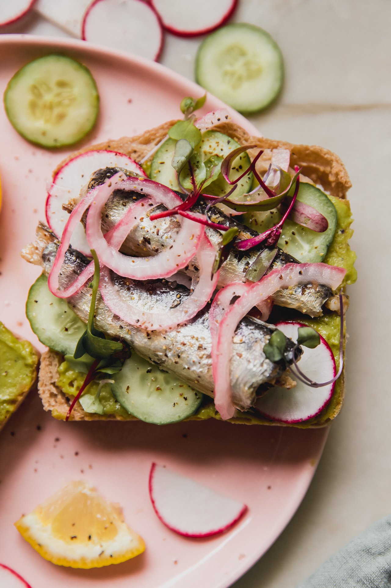 Gluten free toast topped with avocado mash, sardines, cucumber and radish. 