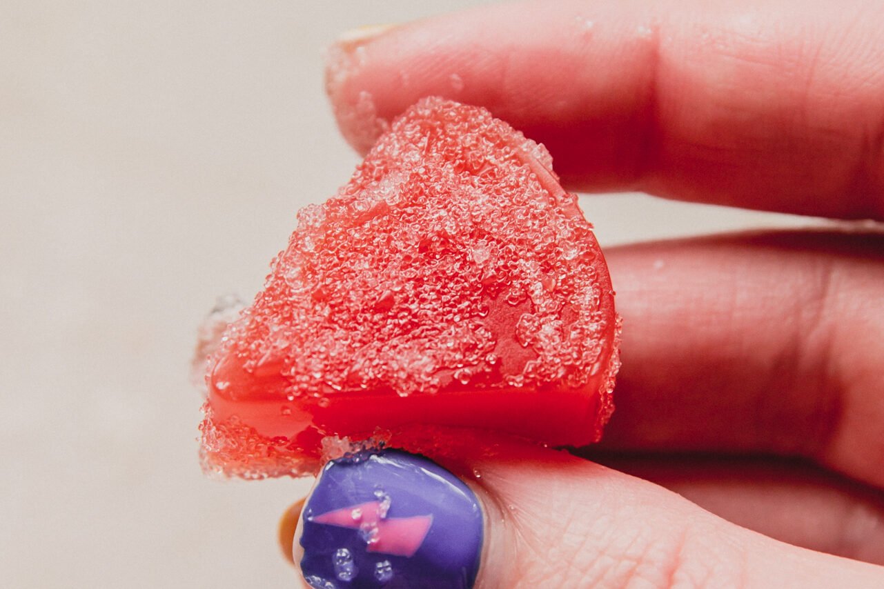 Watermelon gummy being held.