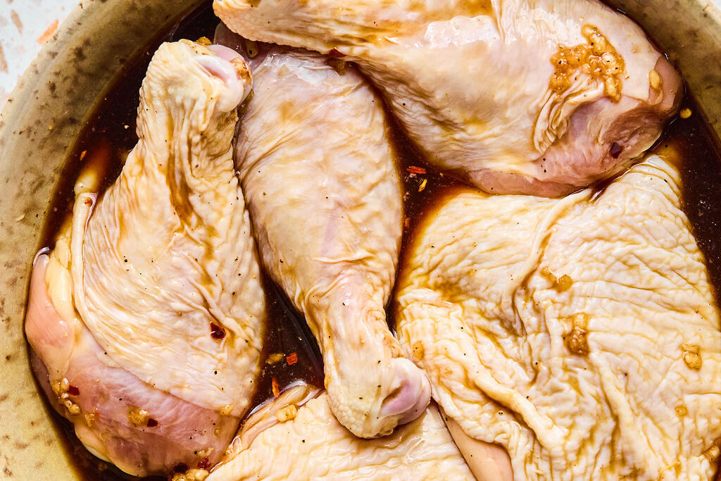 The raw chicken marinating before cooking. 