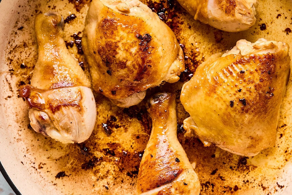 The chicken searing in a pan.