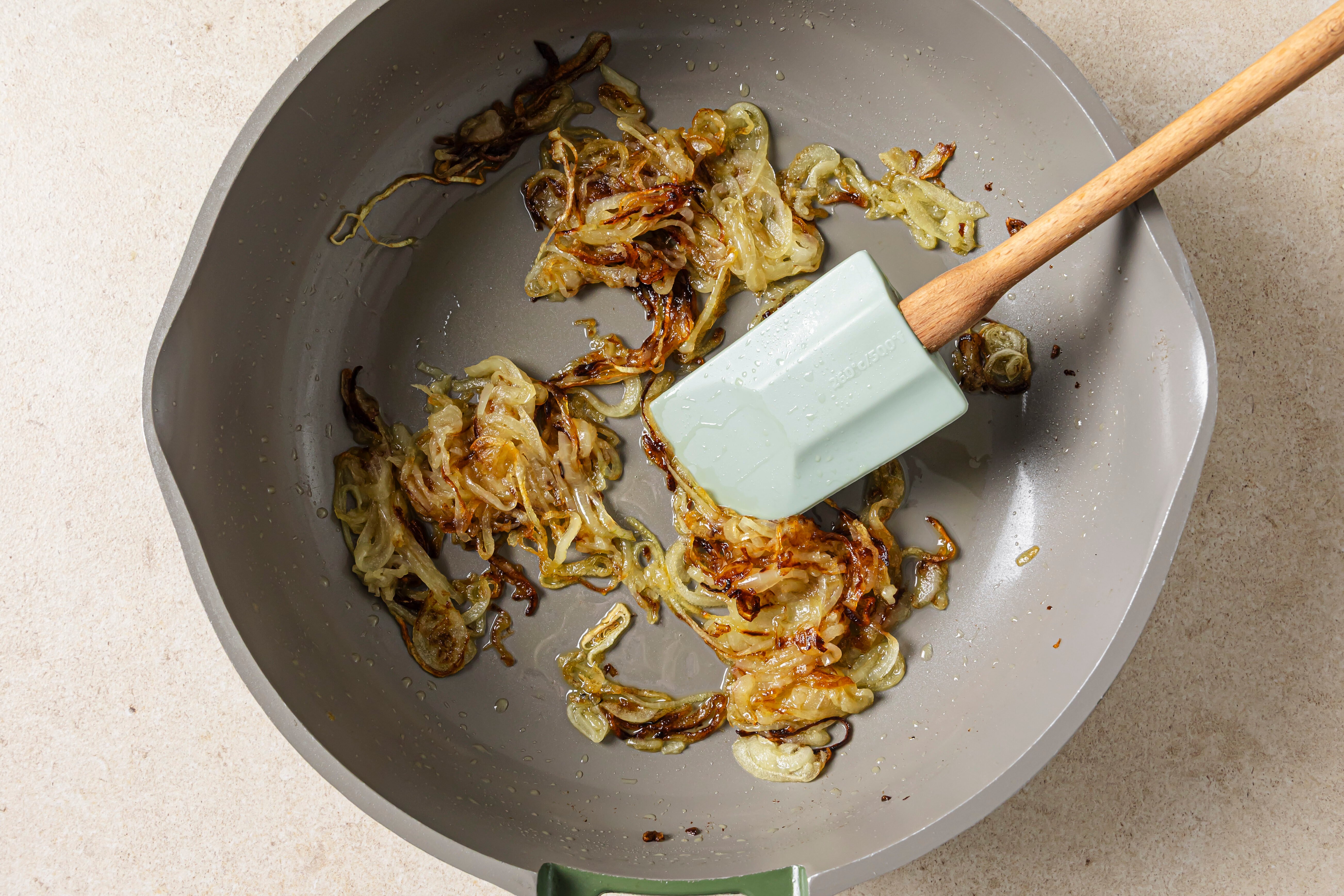 The onions caramelizing in a pan.