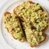 Avocado salmon salad on two slices of toast.