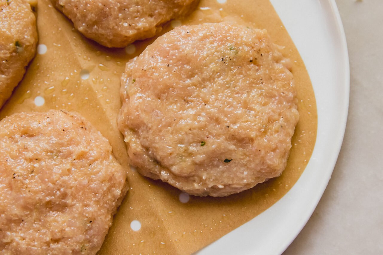 A plate with chicken patties formed on it before cooking.