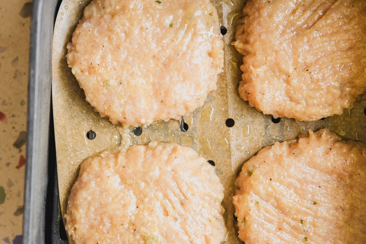 The chicken patties in the air fryer before cooking.