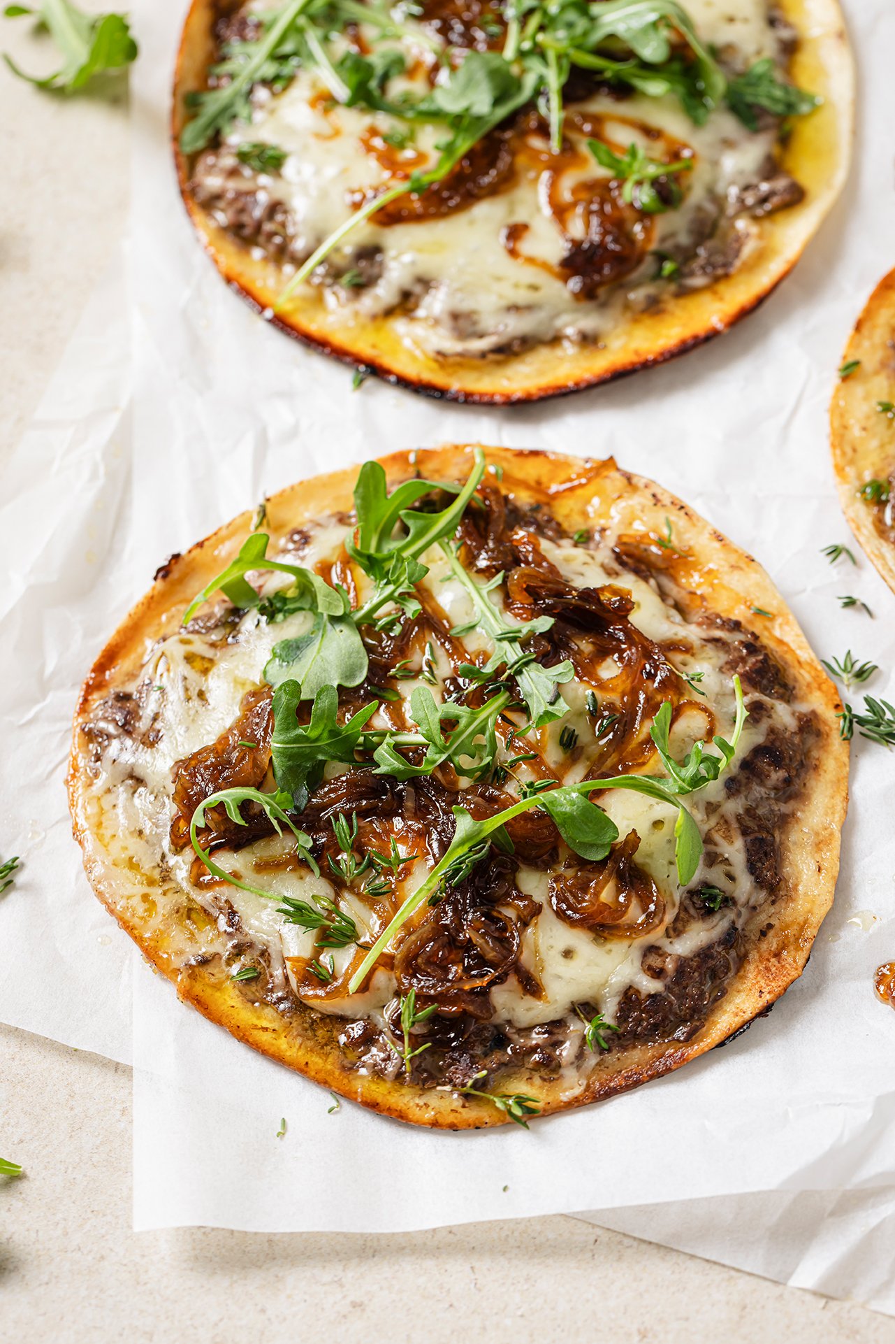 French onion smashburger tacos topped with arugula. 