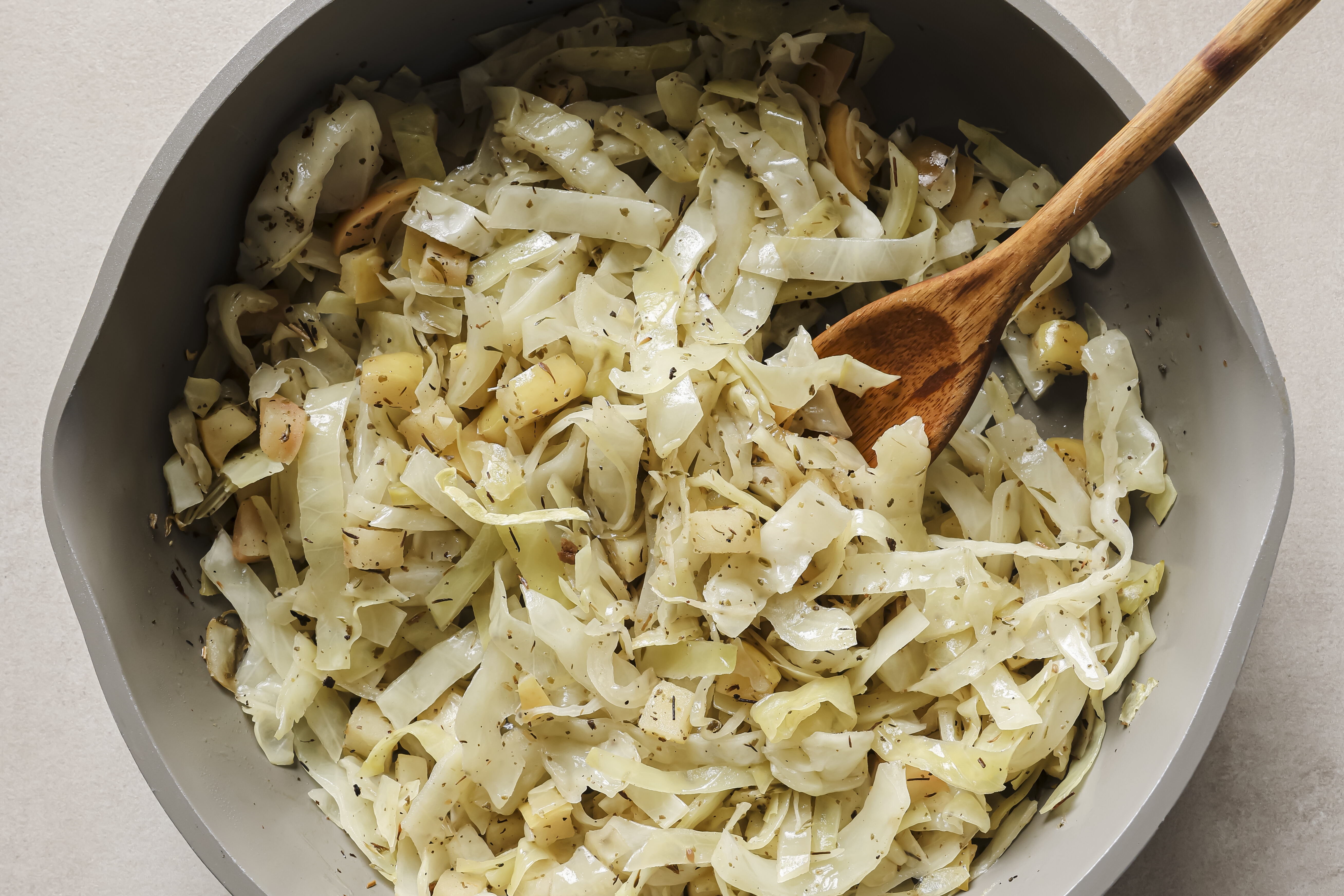 The cabbage and apples sauting in the pan.