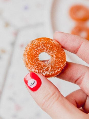 Protein peach ring being held up.