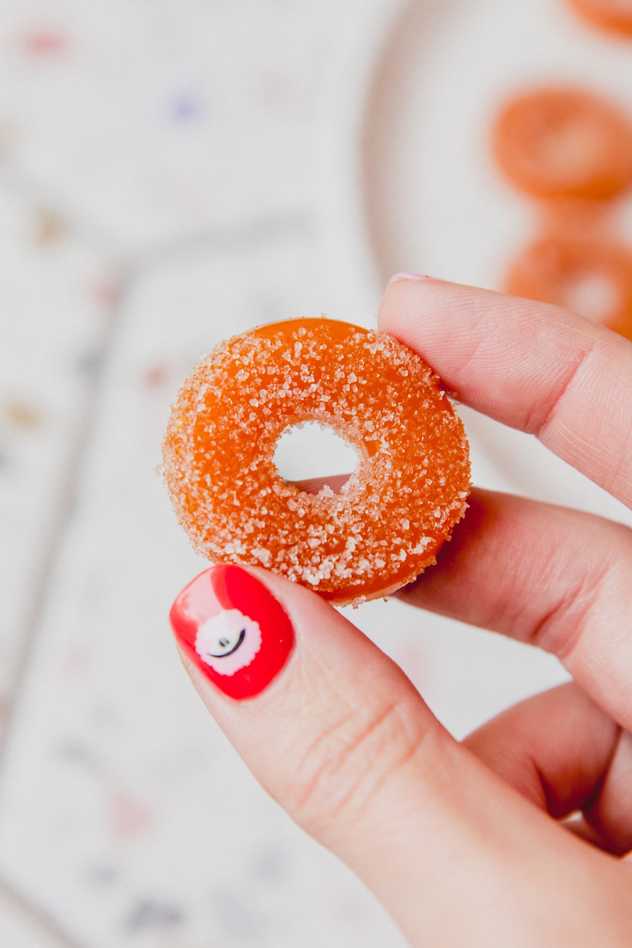 Protein peach ring being held up.
