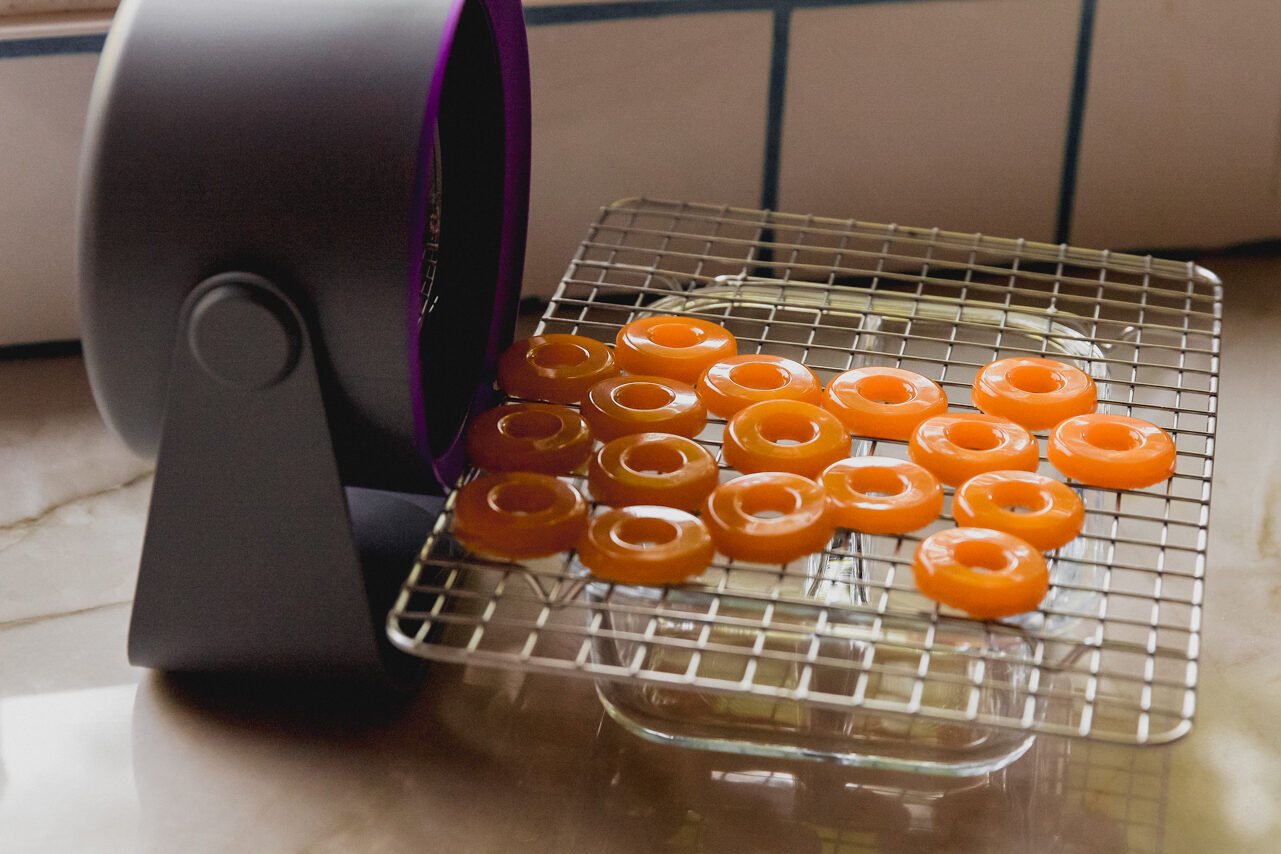 Protein peach rings drying on a rack.