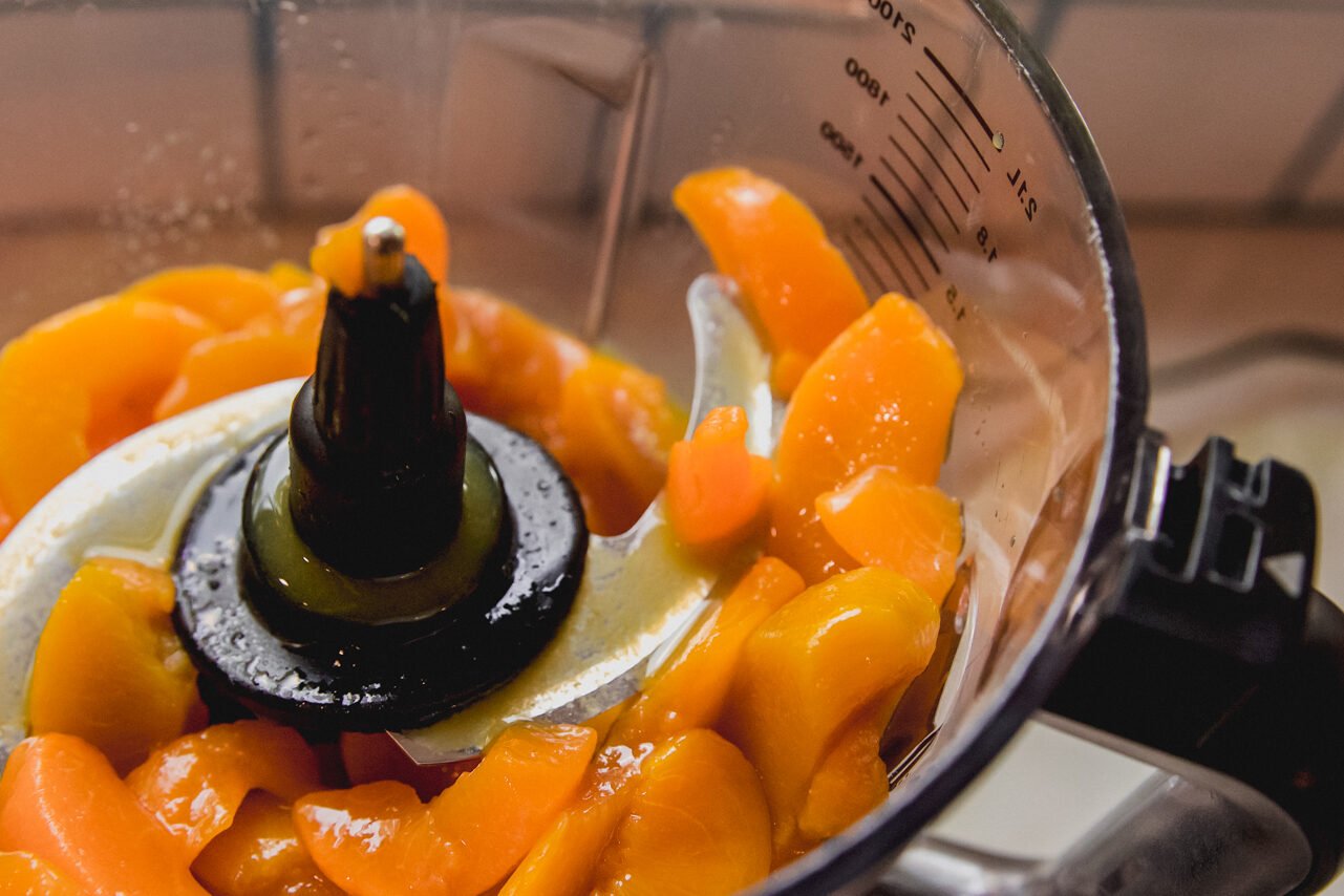 Sliced peaches in a food processor.