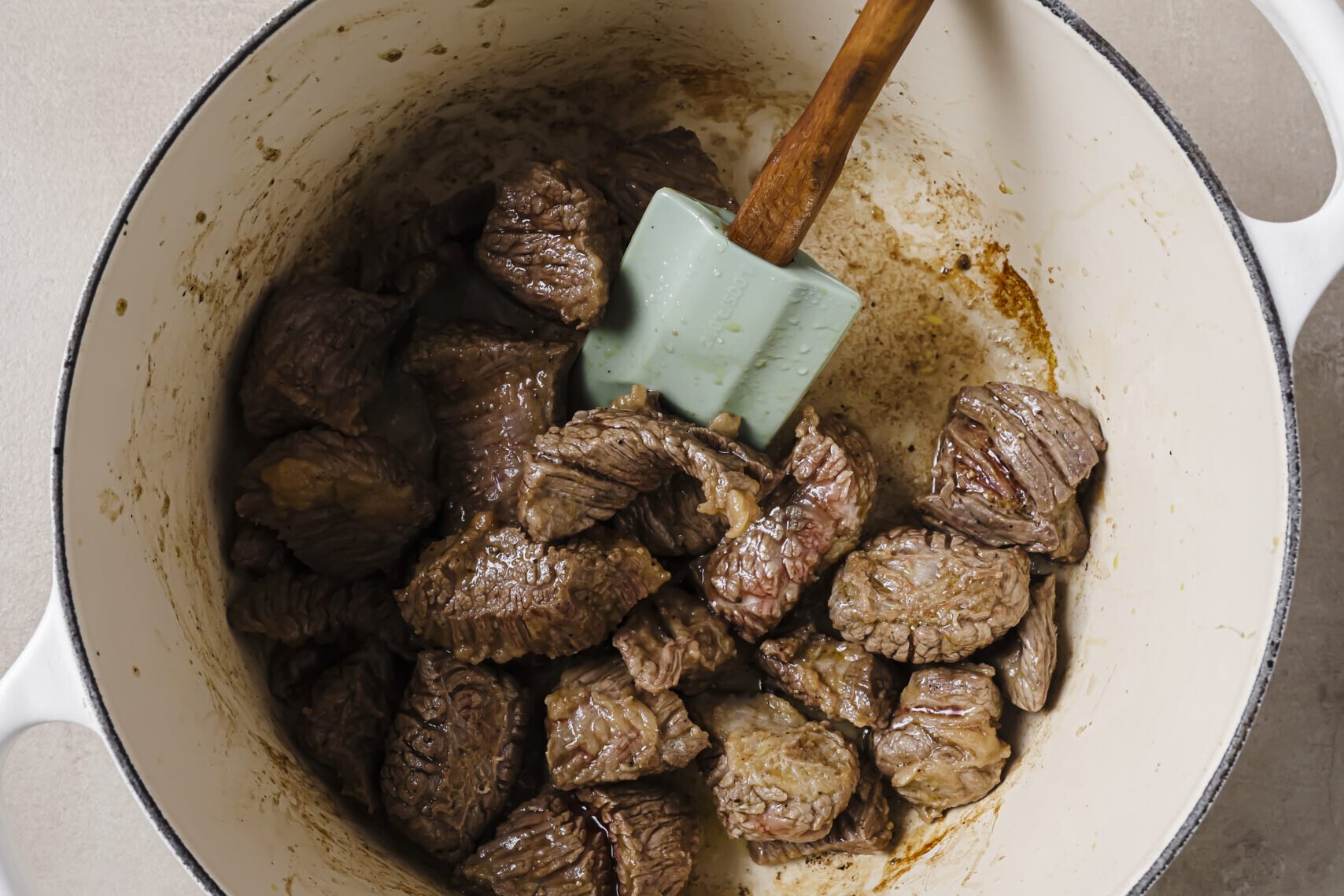 Beef stew meat cooked in a pot.