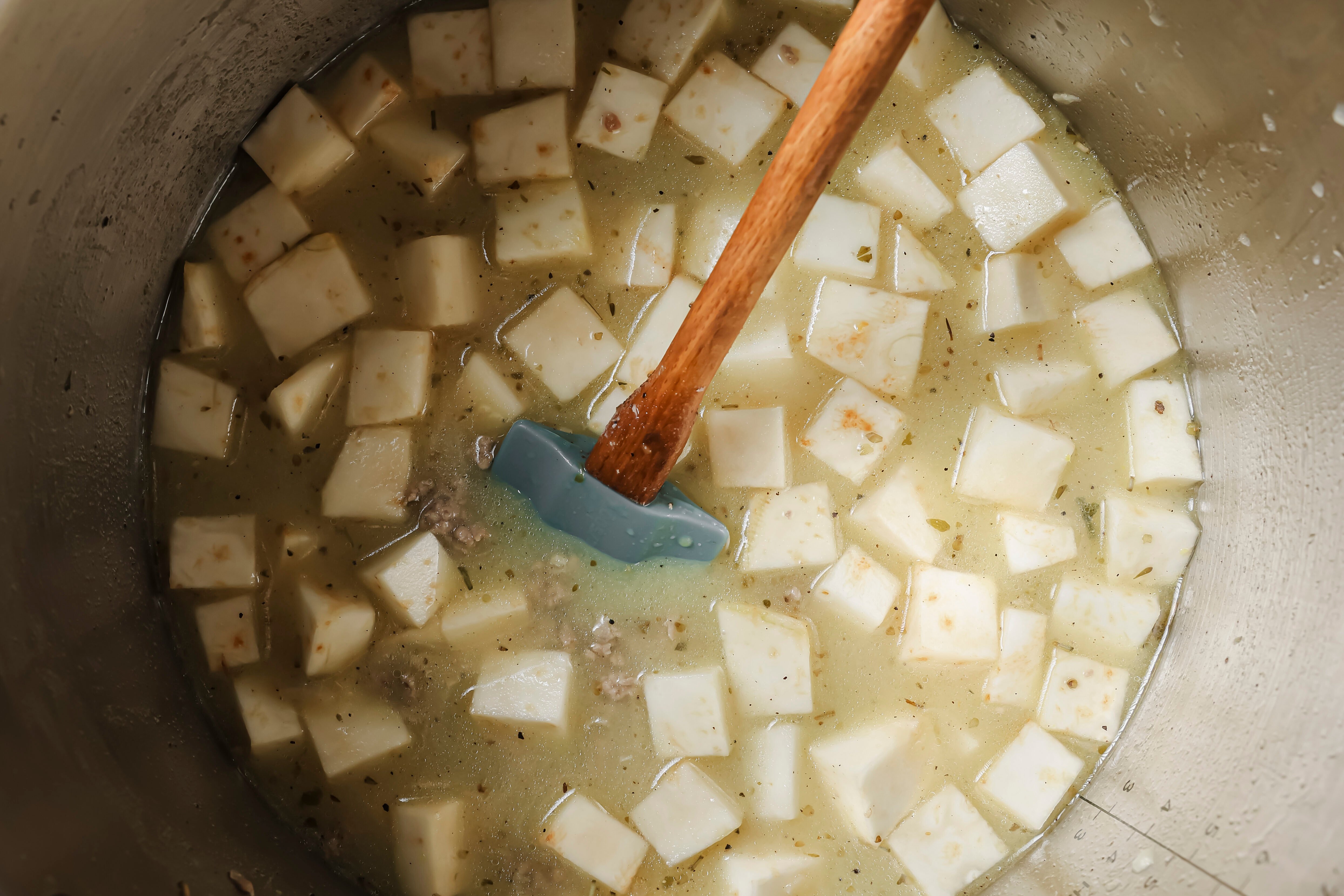 The broth and potatoes added to teh instant pot before cooking.