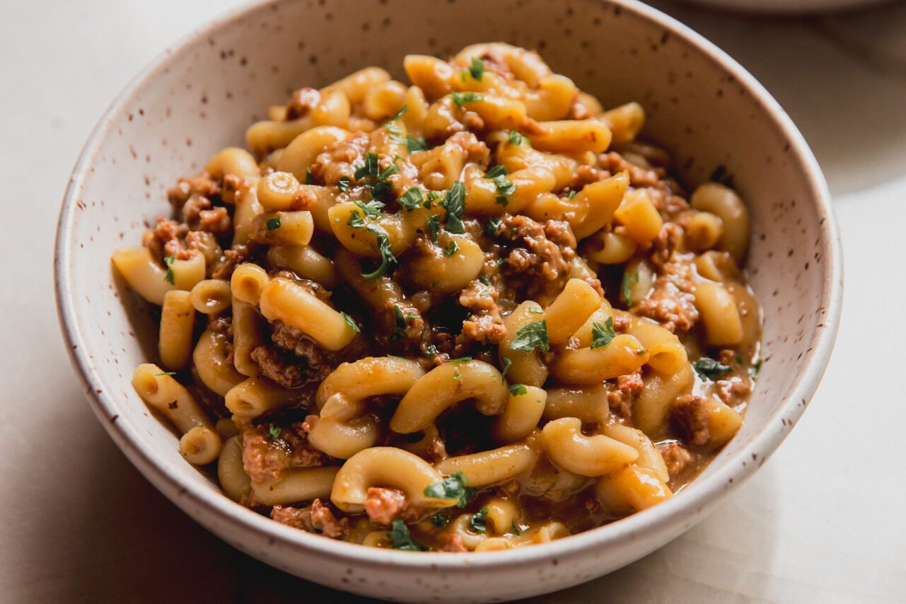 A bowl of slow cooker hamburger helper topped with parsley and ready to be eaten. 