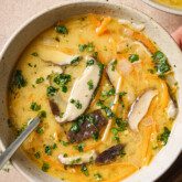 Tom kha soup with a spoon.