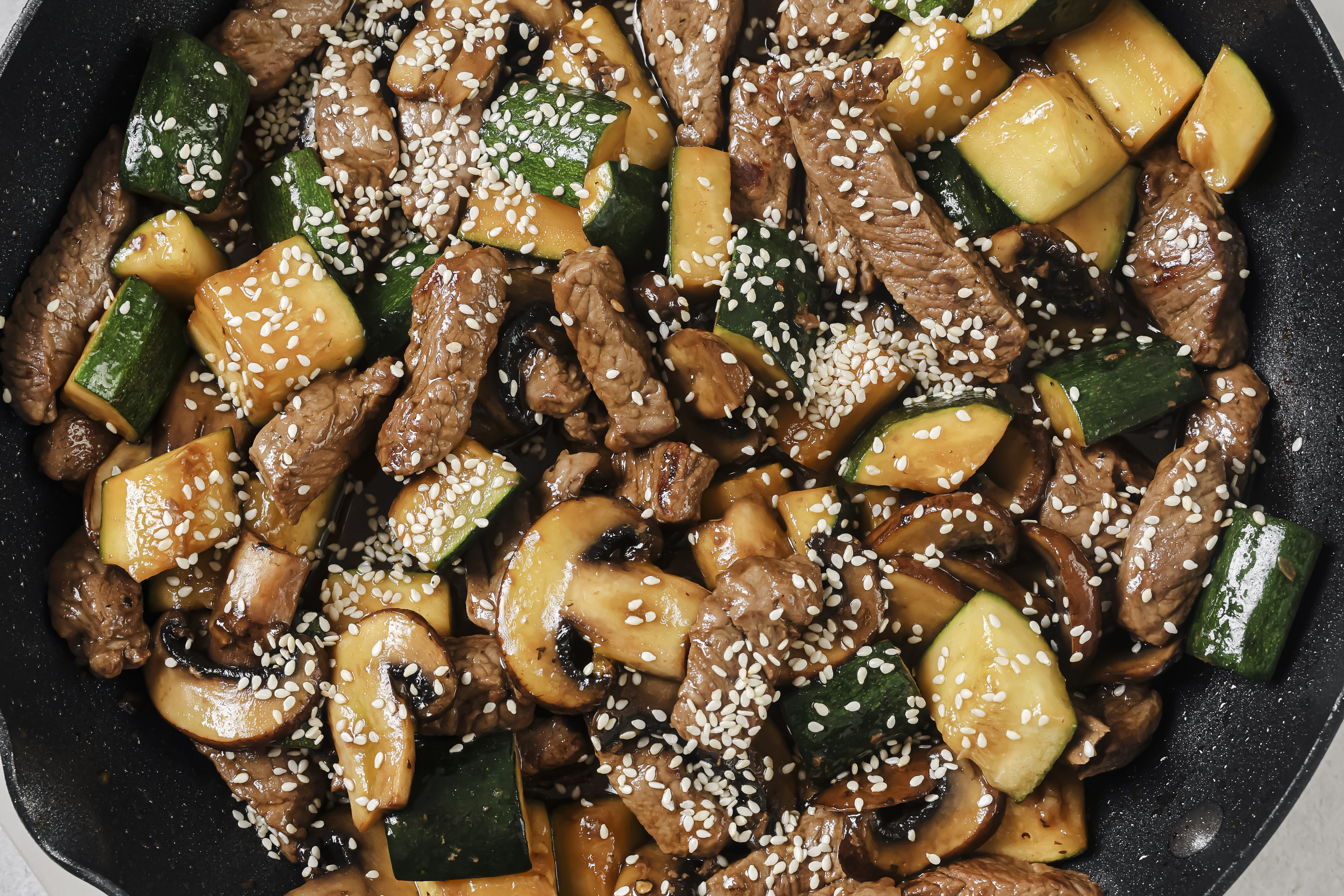 Beef and zucchini stir fry in a pan.