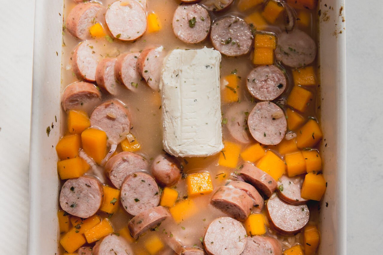 The ingredients for chicken sausage and orzo in the baking dish.