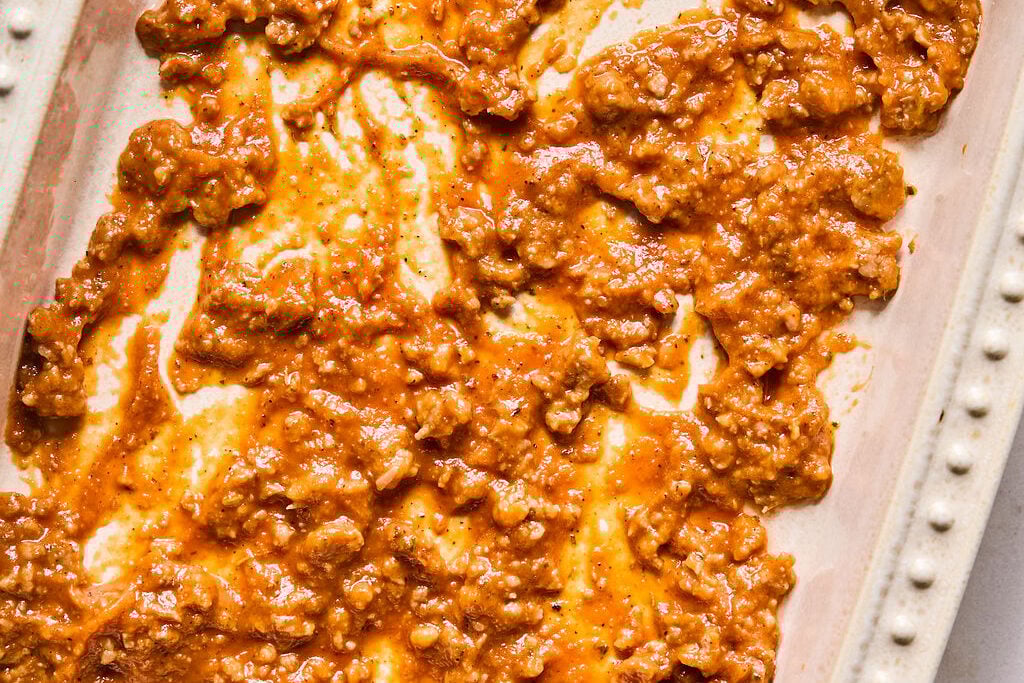 The bottom of the baking dish with some ground sausage and sauce on it.