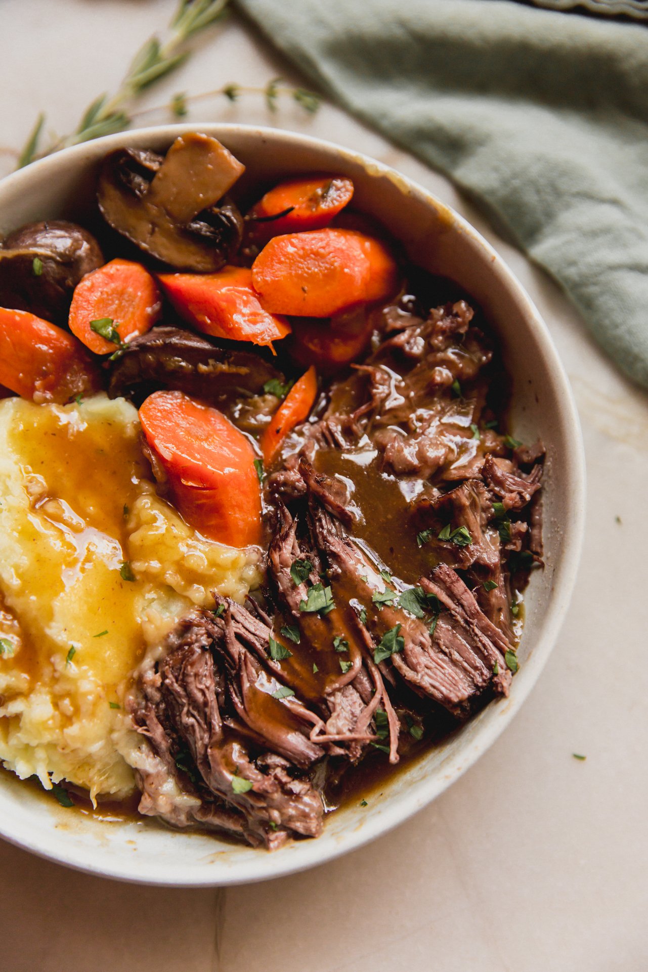 pot roast with gravy with a side of veggies and sweet potato.
